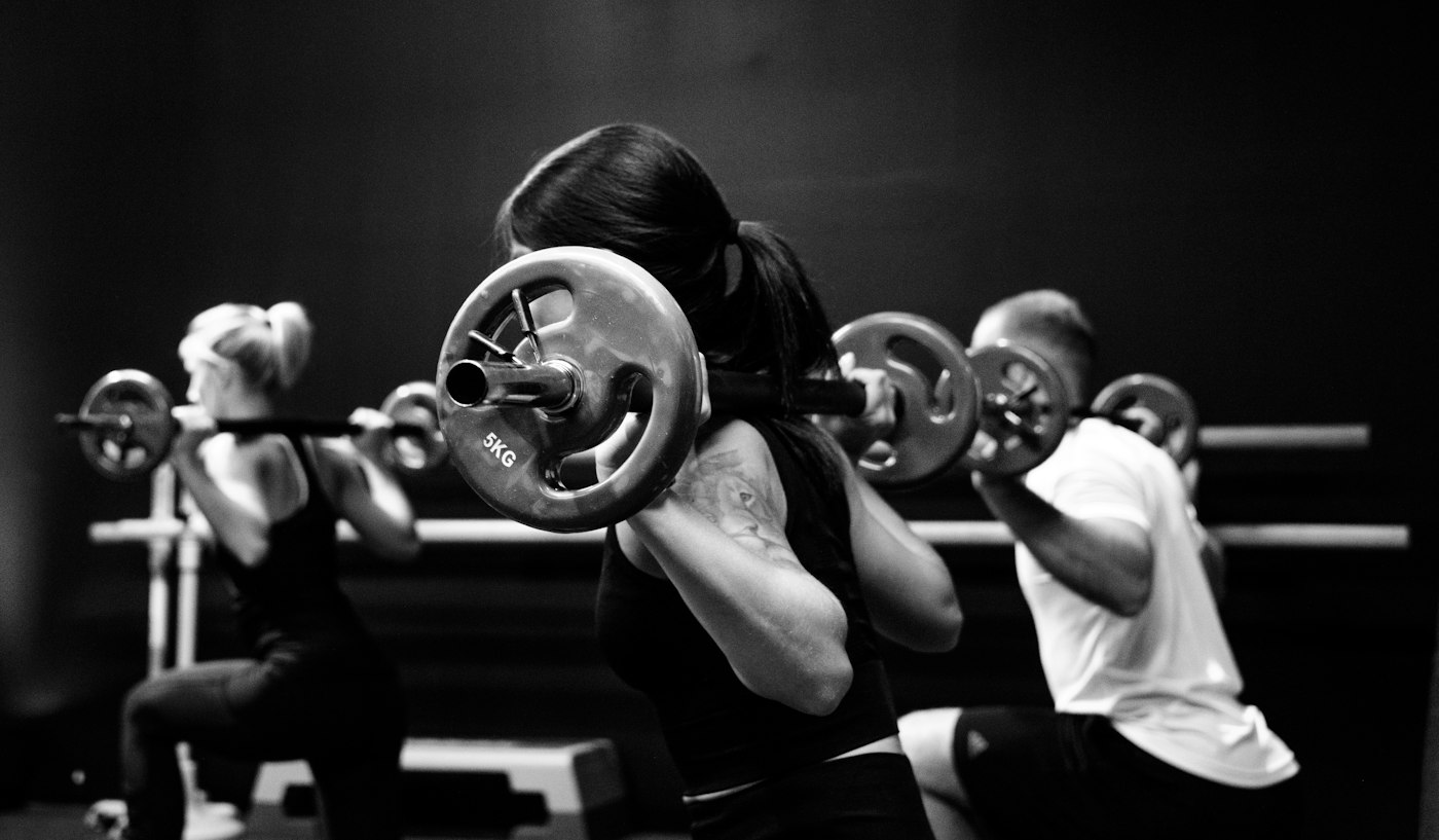 Petit groupe en squat barre lors d'une session collective