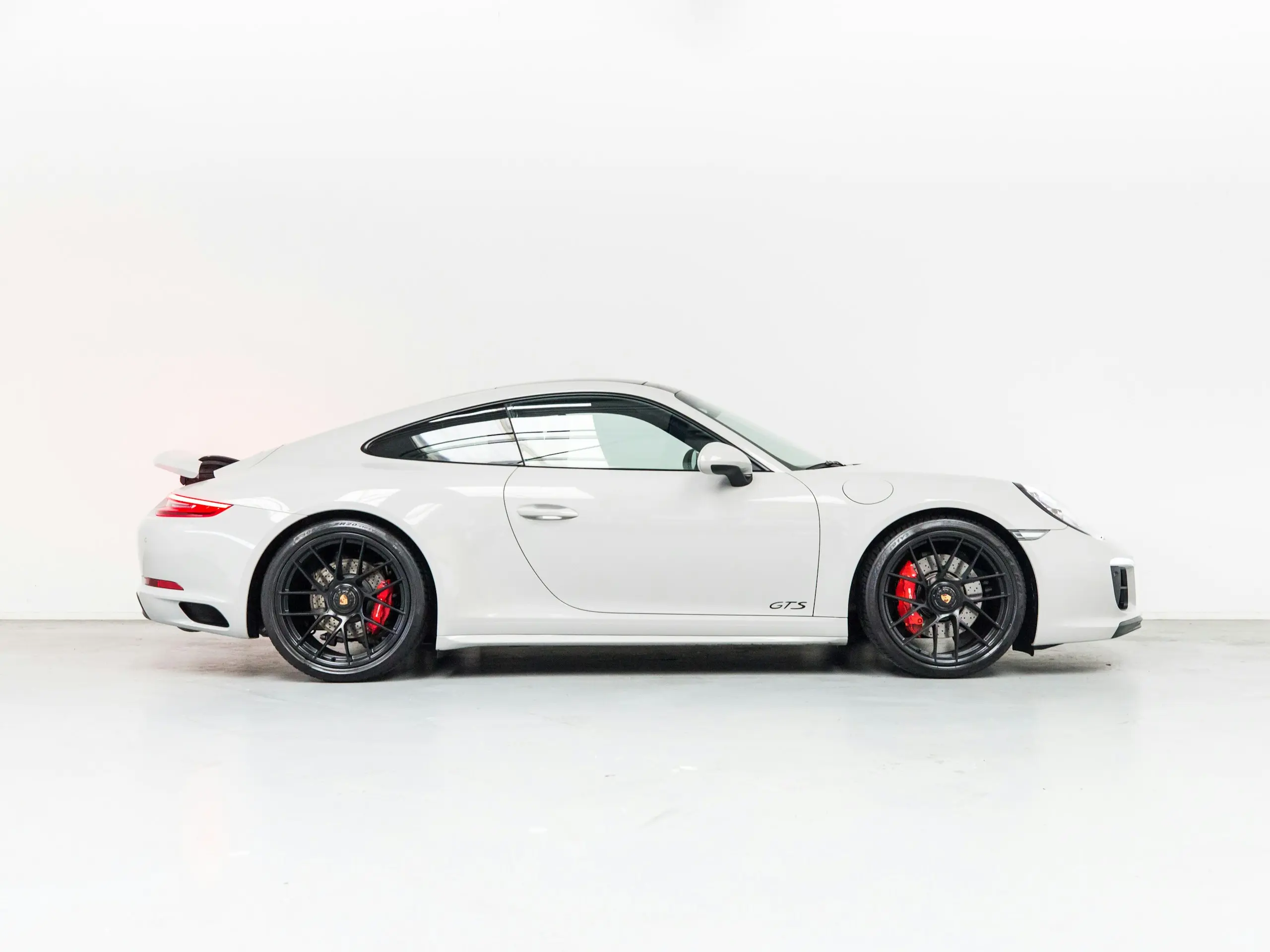 Coupé blanc présenté de profil dans un studio blanc, jantes noires (photographie d’illustration).