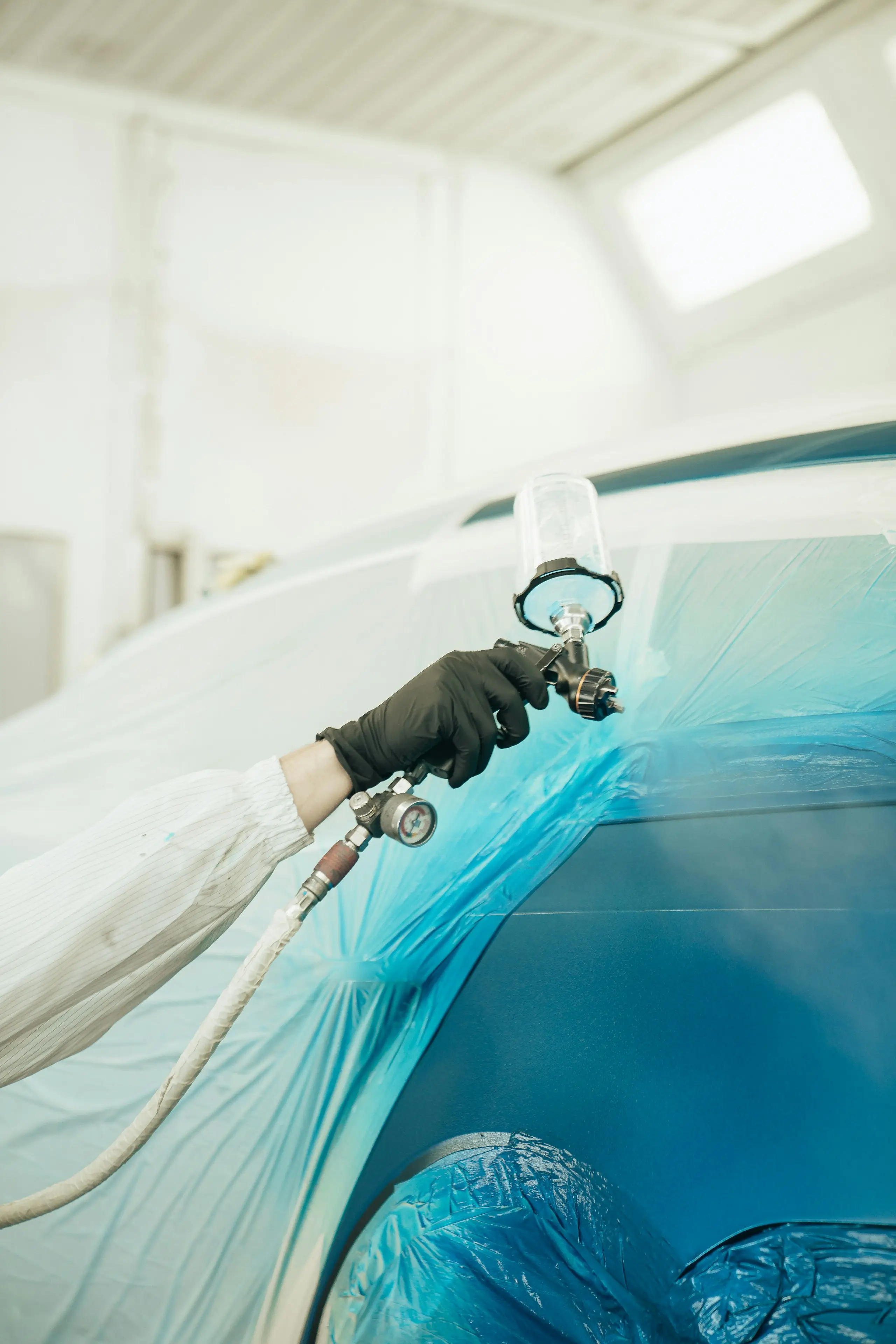 Application de peinture au pistolet dans une cabine